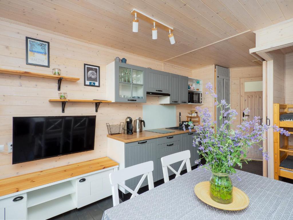 a kitchen with a table with a vase of flowers at Szum Fal in Rusinowo