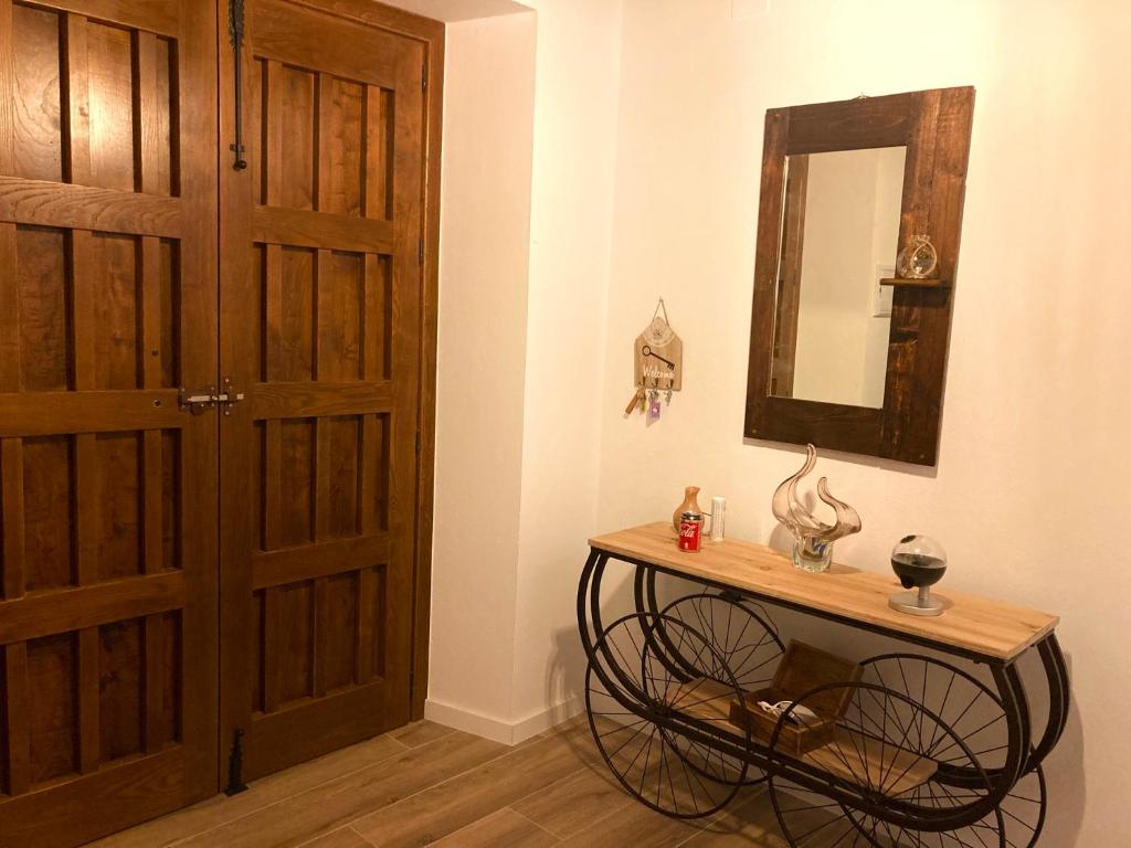 Cette chambre dispose d'une porte et d'une table avec un miroir. dans l'établissement Casa Mercedes y Pepe, à Aracena