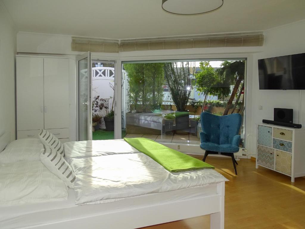 Cama blanca en habitación con ventana grande en Ahrterrassen Penthouse, en Bad Neuenahr-Ahrweiler