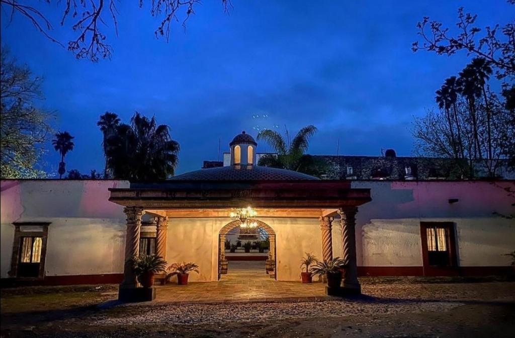 una entrada a un edificio con un arco por la noche en Hotel Spa Hacienda Real la Nogalera en Tequisquiapan