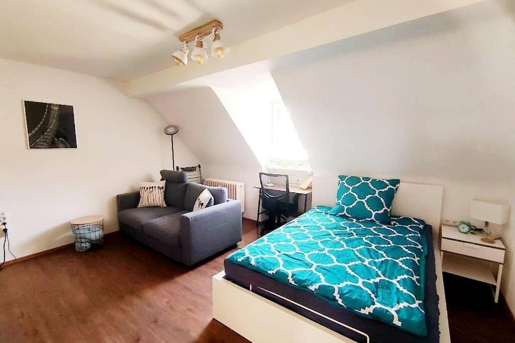 een woonkamer met een bed en een bank bij Gemütliches Apartment Nähe DU Zentrum/Uni/Hbf/A40 in Duisburg