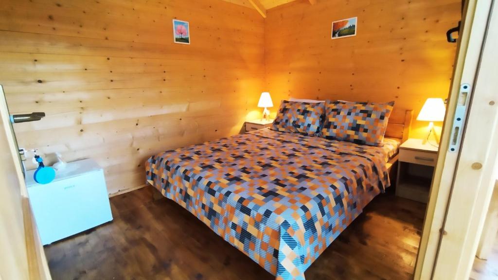 a bedroom with a bed in a room with wooden walls at Camp Sunny Hills in Virpazar