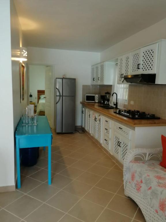 a kitchen with a blue table and a refrigerator at Playa Turquesa only 50m From the Beach Walk to all Restaurants in Las Terrenas