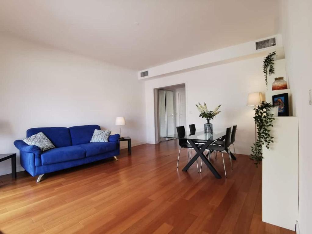 a living room with a blue couch and a table at LA PLAGE - Hyper centre - vue port & mer - Climatisation in Cassis