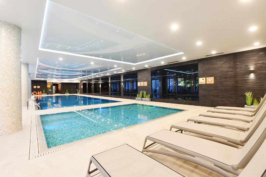 a swimming pool in a hotel with lounge chairs at Klif Apartamenty Nadmorskie Tarasy C403 in Kołobrzeg
