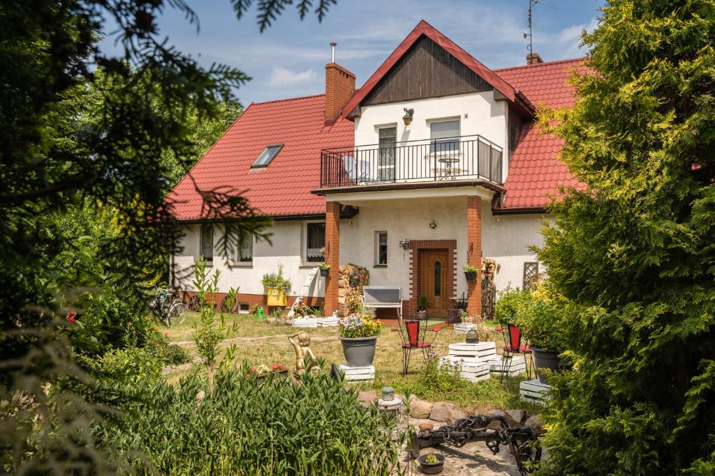 une grande maison blanche avec un toit rouge dans l'établissement Sielski wypoczynek blisko Kołobrzegu, à Dębogard