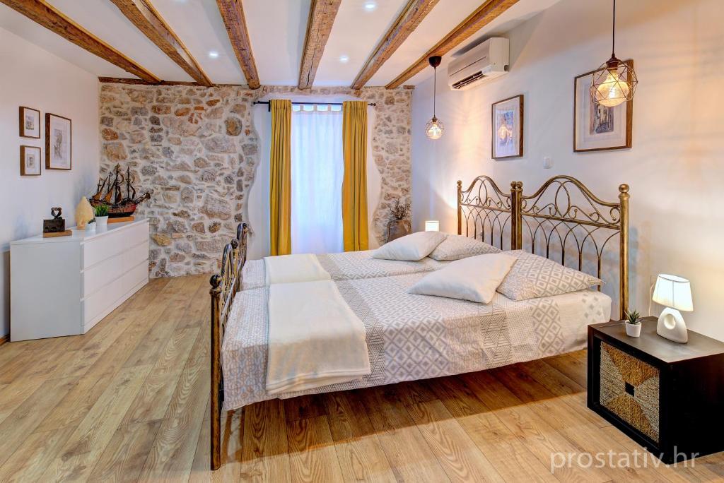 a bedroom with a bed and a stone wall at Apartment Seka Oldtown in Senj