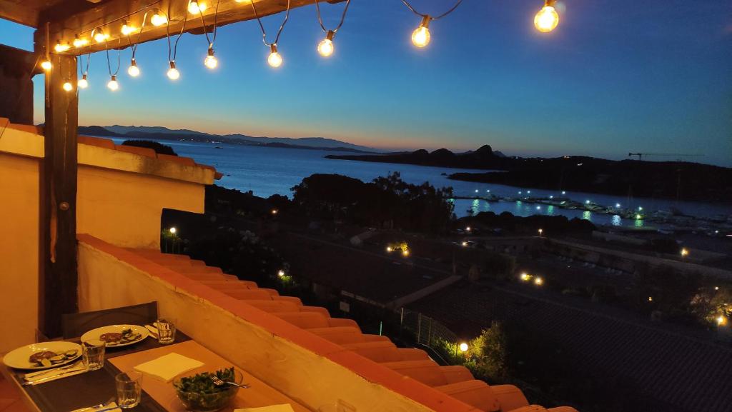 a restaurant with a view of the ocean at night at Blue Bay Apartment in Cala Bitta
