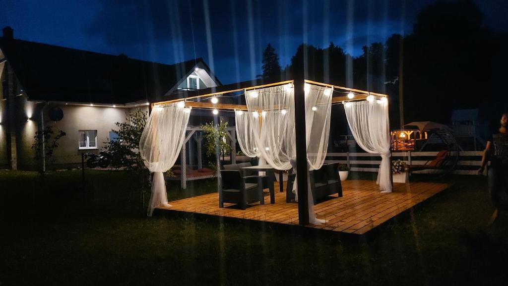 a gazebo with white curtains and a table and chairs at Apartamenty Malwa in Lądek-Zdrój