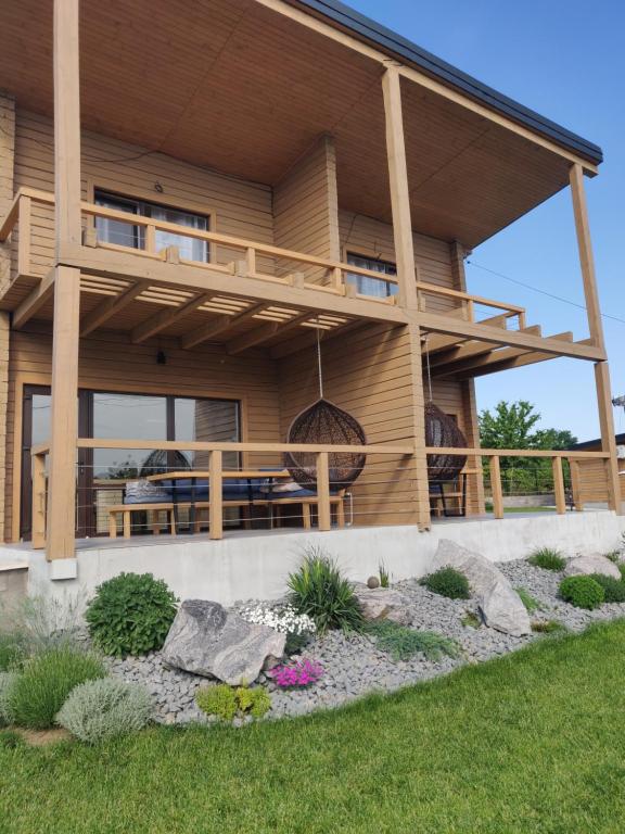 a house with a large deck on the side of it at Шале Рутенія - Chalet Rutenia apartments in Neporotovo