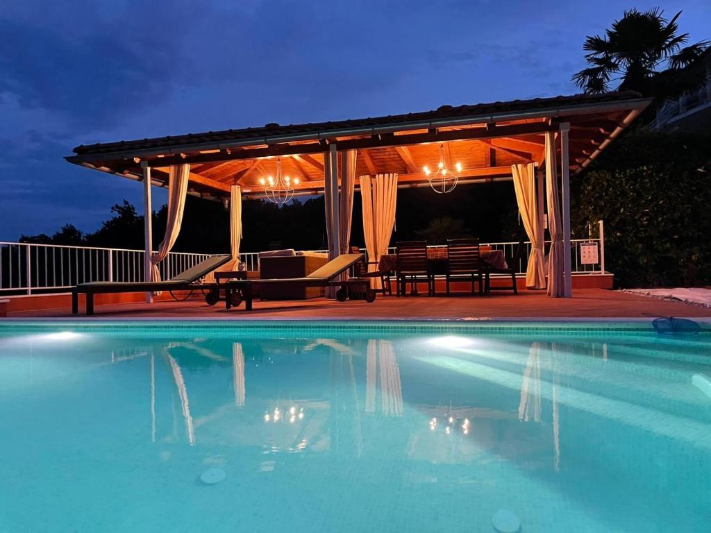 una piscina con cenador y un patio en VILLA LOVRAN - 150m to the beach - infinity pool - incredible sea view - Fitnessraum, en Lovran