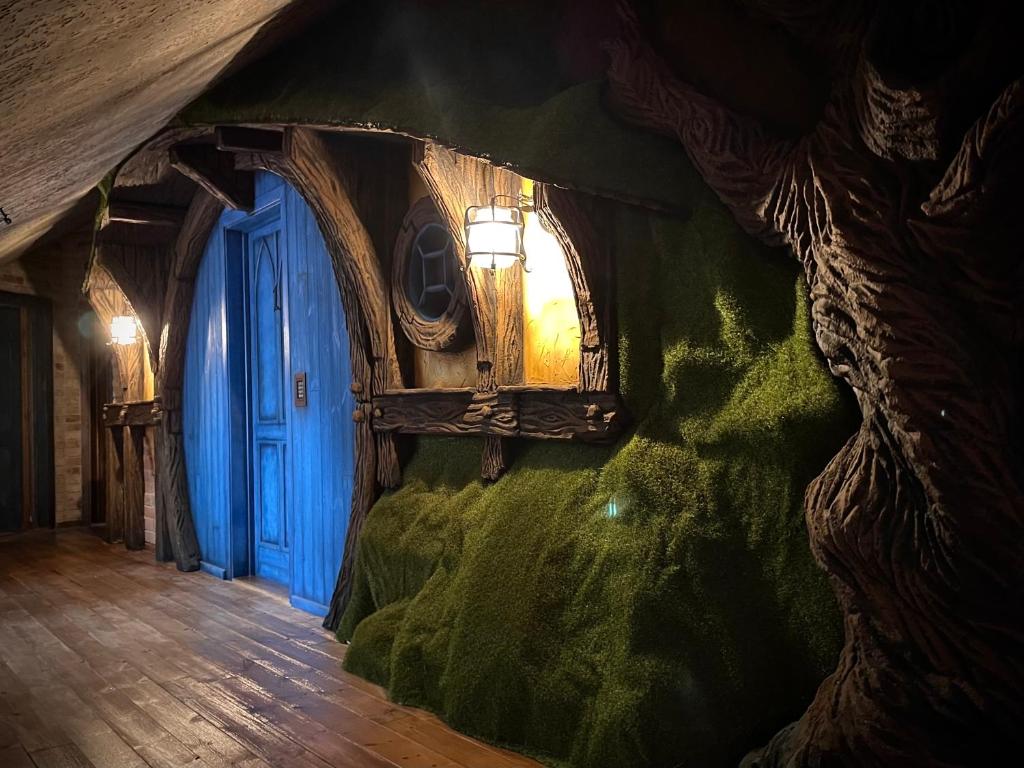 um quarto com uma porta azul e uma parede verde em Excalibur miniHotel em Eger