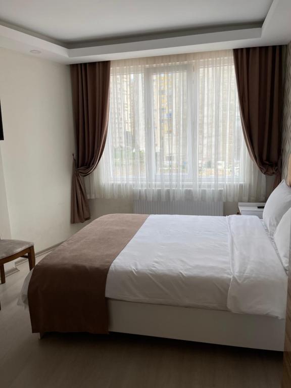 um quarto com uma cama grande e uma janela em Bursa Malkoc Hotel em Bursa