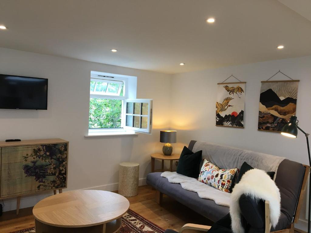 ein Wohnzimmer mit einem Sofa und einem Tisch in der Unterkunft In the Heart of Glastonbury in Glastonbury