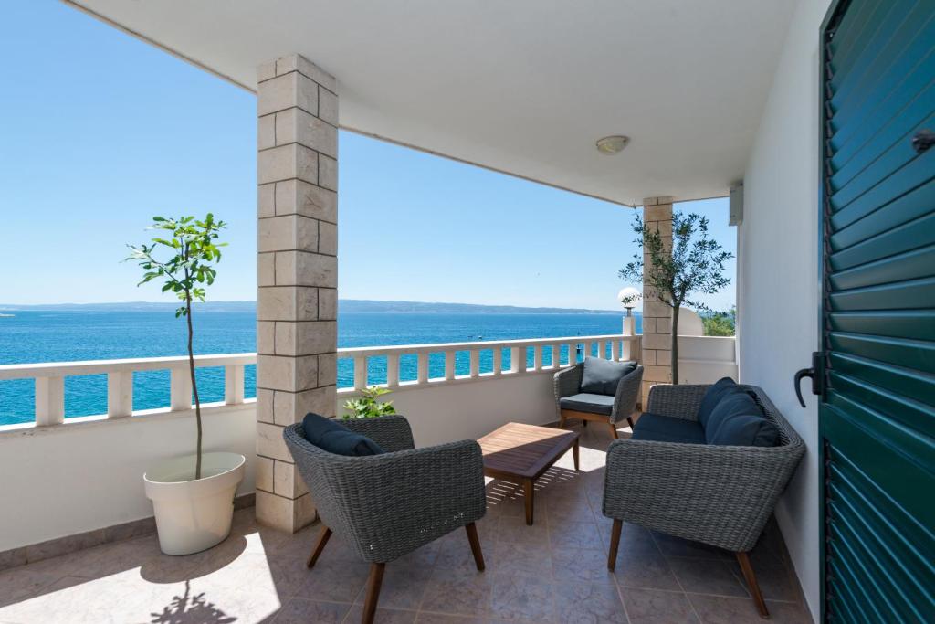 Un balcón con sillas, una mesa y el océano en Beachfront apartments, en Split