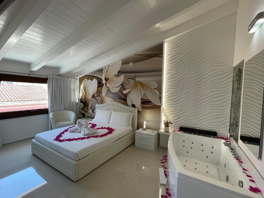 a bedroom with a white bed and a tub at BARRILE'S in Olbia