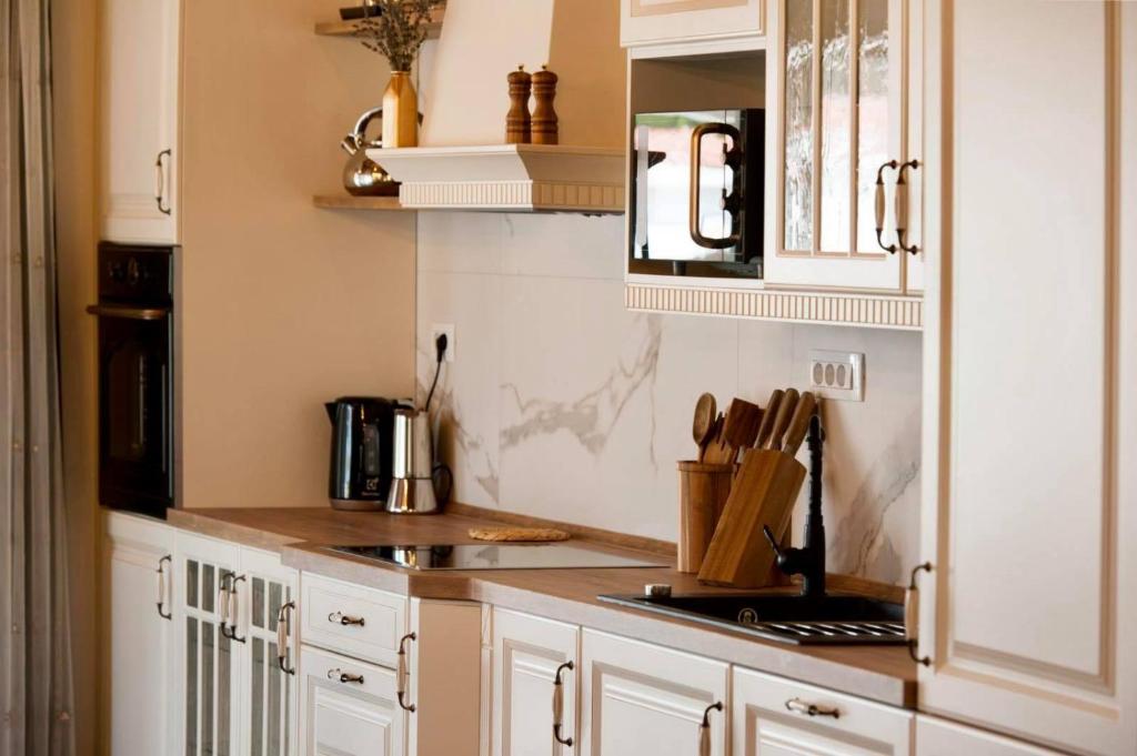 a kitchen with white cabinets and a counter top at Luxury Villa Nature with heated private pool, sauna & fire pit, a short walk to the beach in Milna
