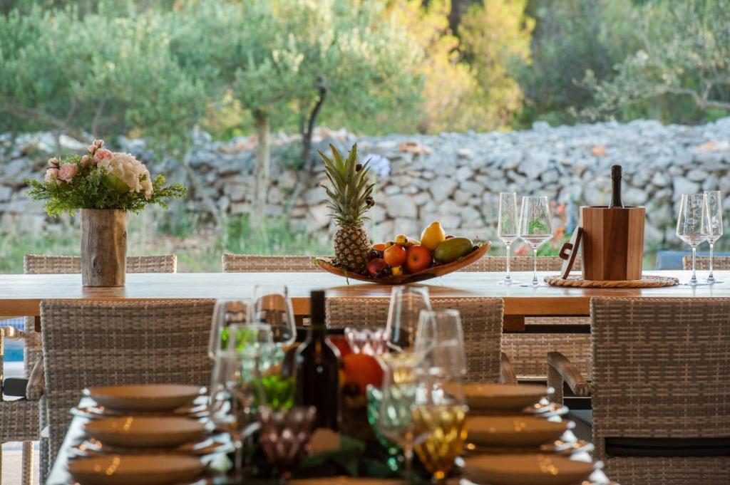 a table with a bowl of fruit on it at Luxury Villa Nature with heated private pool, sauna & fire pit, a short walk to the beach in Milna