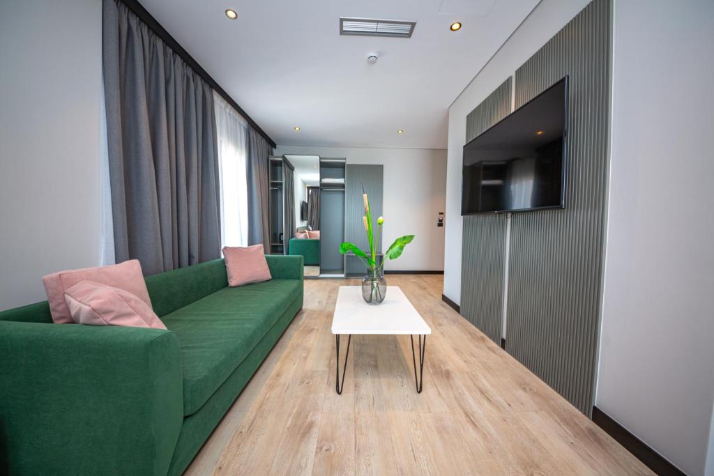 a living room with a green couch and a table at Apart-Hotel Lili2 in Sarandë