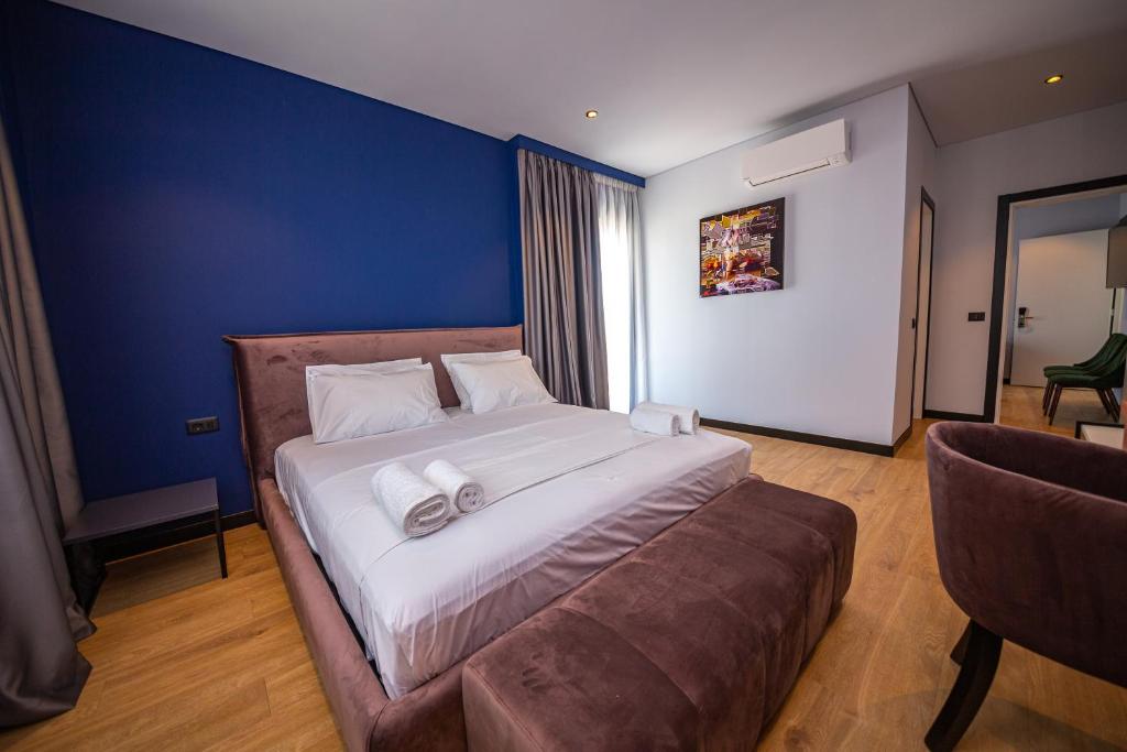 a bedroom with a large bed and a couch at Apart-Hotel Lili2 in Sarandë
