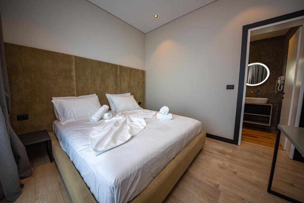 a bedroom with a white bed with towels on it at Apart-Hotel Lili2 in Sarandë