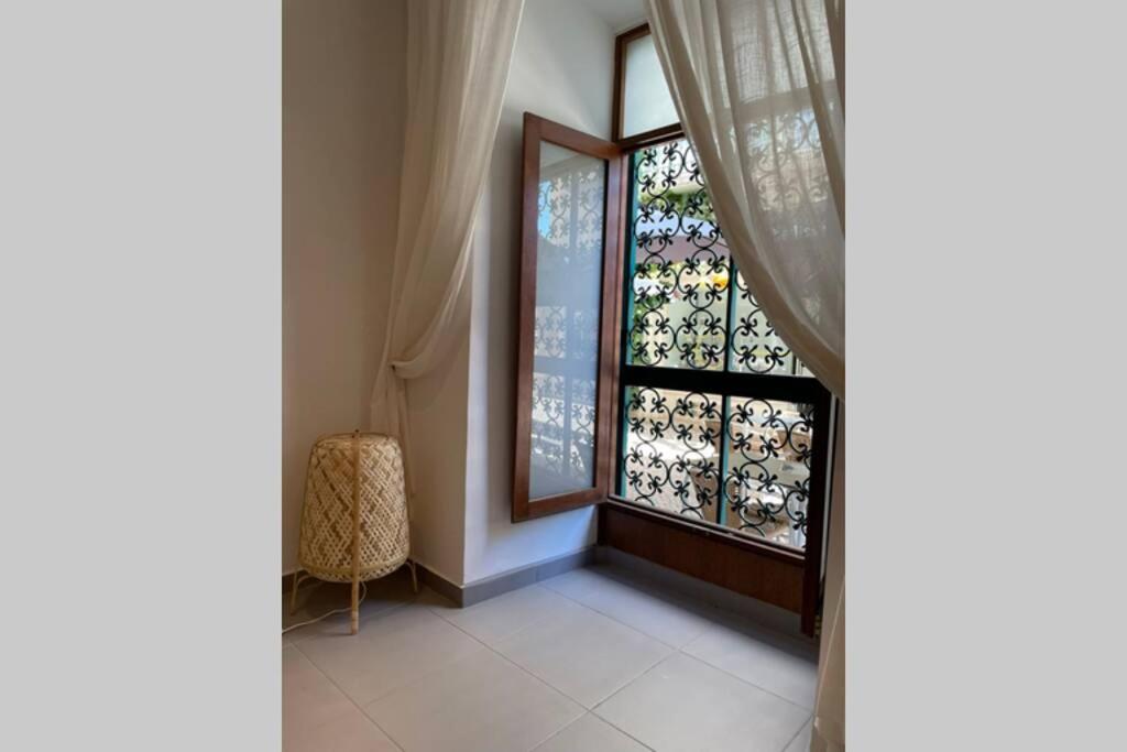 Cette chambre comprend une fenêtre avec un rideau et une chaise. dans l'établissement Janelas Verdes 37, à Faro