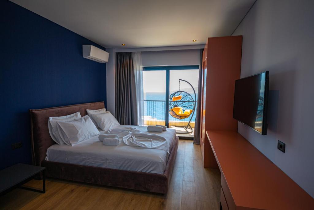 a bedroom with a bed with a view of the ocean at Apart-Hotel Lili2 in Sarandë