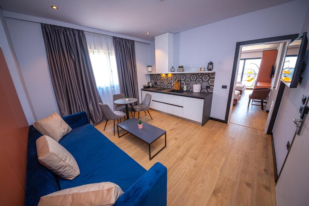 a living room with a blue couch and a kitchen at Apart-Hotel Lili2 in Sarandë