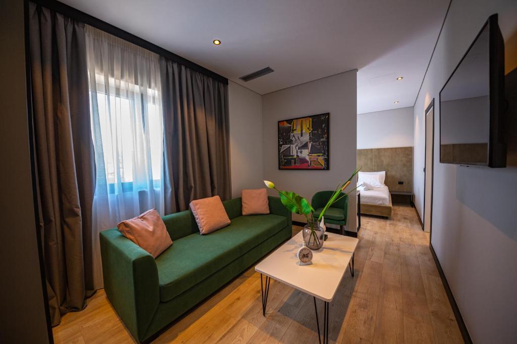 a living room with a green couch and a table at Apart-Hotel Lili2 in Sarandë