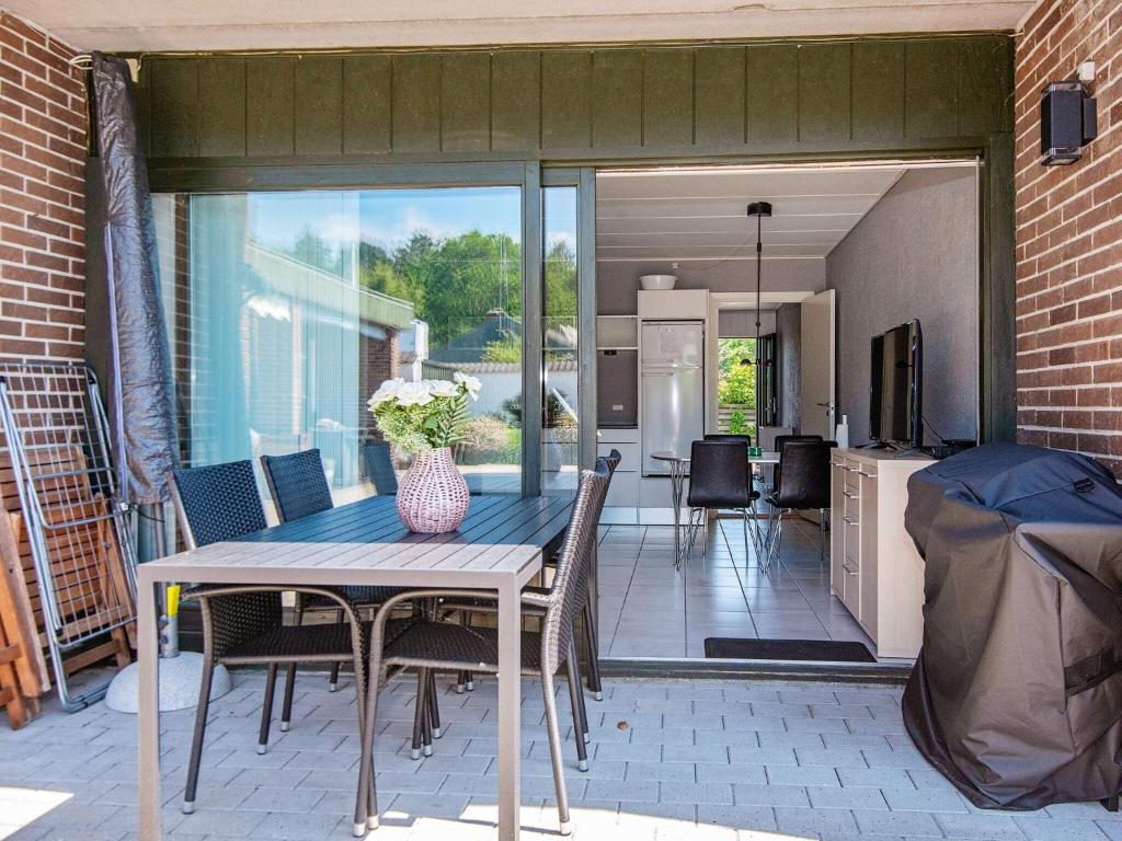 un patio con tavolo e sedie e una cucina di Apartment Glesborg CVI a Glesborg