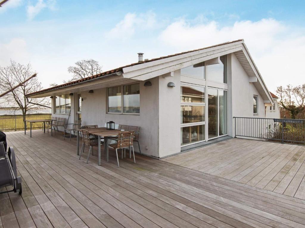 Årøsundにある12 person holiday home in Haderslevのデッキ(テーブル、椅子付)が備わる家