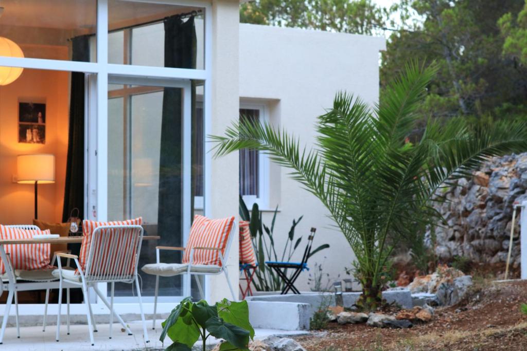 a patio with chairs and a table and a palm tree at House L E T A in Rukavac