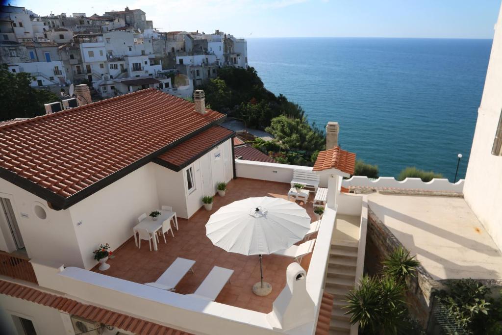 - une vue sur une maison avec un parasol et l'océan dans l'établissement Blumarine Suite, à Peschici