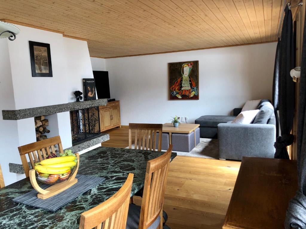 - un salon avec une table, des chaises et un canapé dans l'établissement Cozy Apartment With Stunning View, à Gsteig