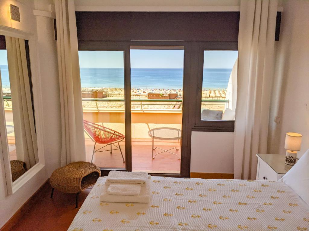 Un dormitorio con una cama y vista al mar. en Seasun Vacation Rentals - OCEAN, en Monte Gordo