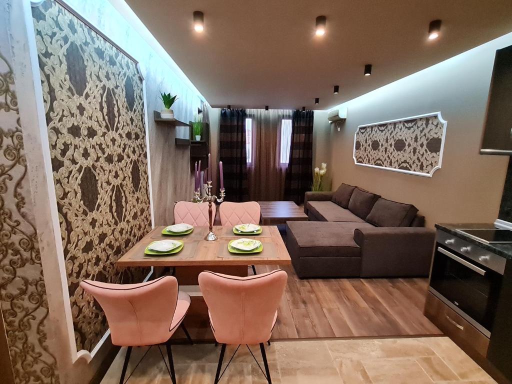 - un salon avec une table, des chaises et un canapé dans l'établissement MitProt Panorama Bay 2 luks apartment ap.73, à Sveti Vlas
