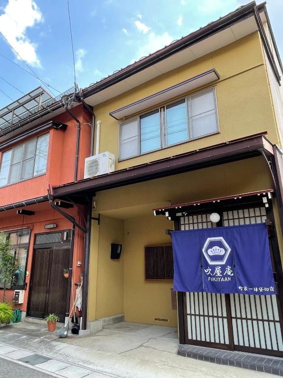 ein Gebäude mit einem blauen Schild an der Vorderseite in der Unterkunft 吹屋庵 in Takayama