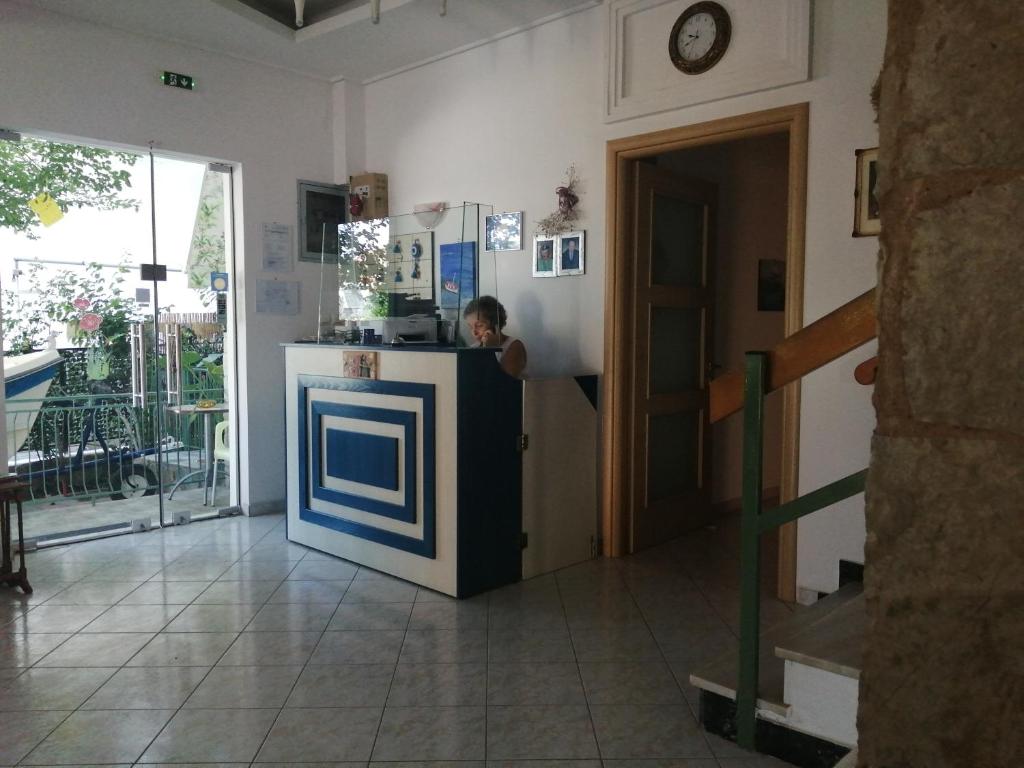 a man standing at a counter in a kitchen at Hotel Fotini in Kamena Vourla