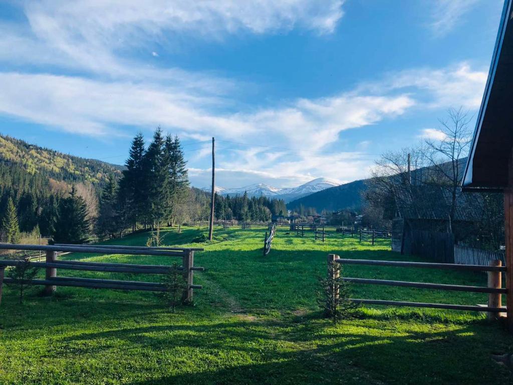 a field with two wooden fences and mountains in the background at Під Явором in Vorokhta