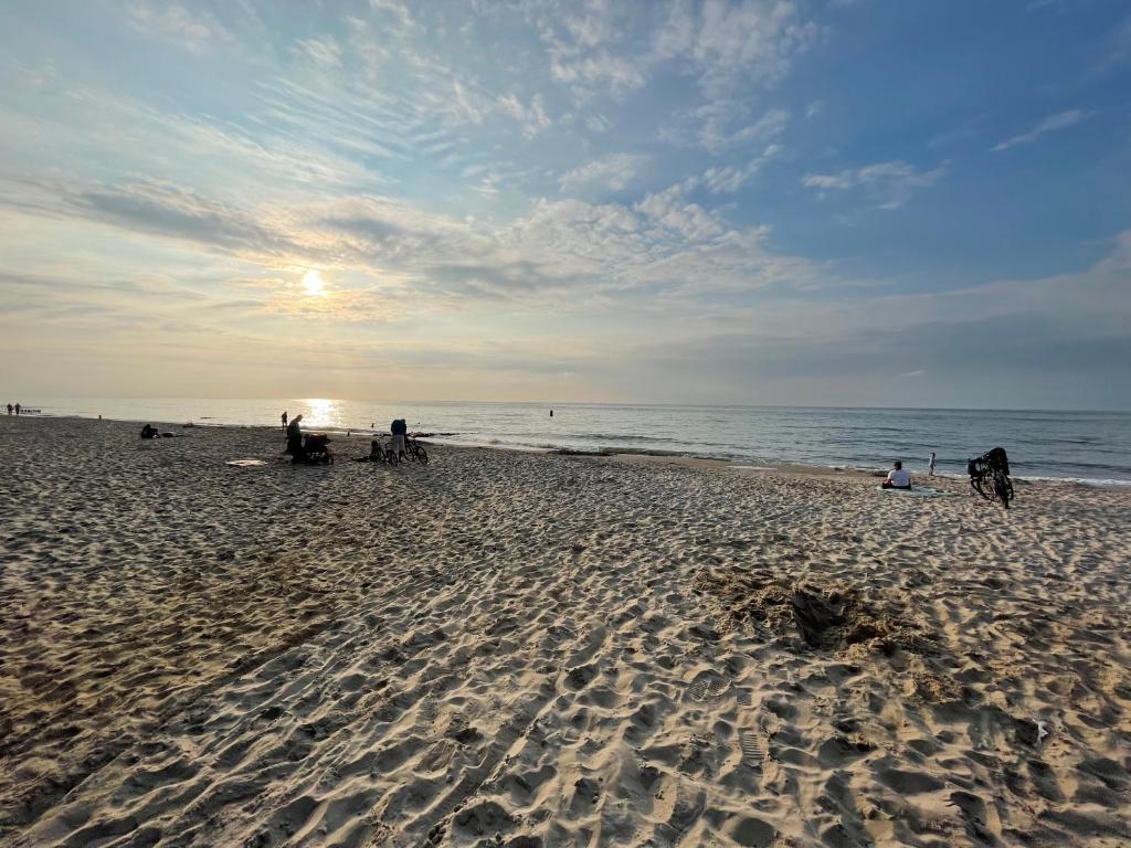 Grupa ludzi na plaży z widokiem na ocean w obiekcie Gąski Apartament Nadmorski w Gąskach