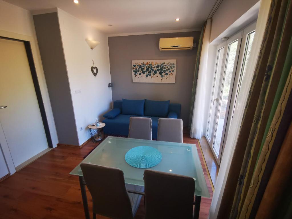 a living room with a blue couch and a table at Airport Garden Apartments in Čilipi