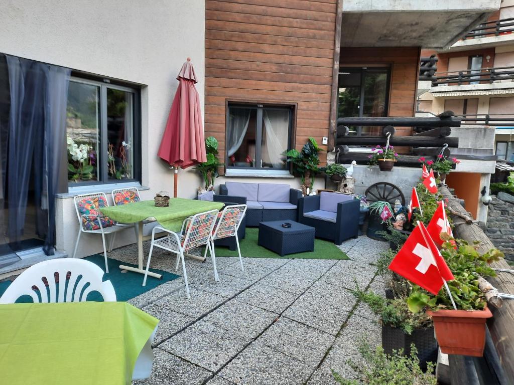 a patio with a table and chairs and an umbrella at Bodmen 3 Apartments von Privat in Zermatt in Zermatt