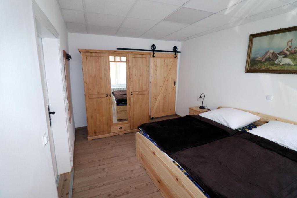 1 dormitorio con 1 cama y puerta de madera en Gästezimmer zum rotem Karpfen, en Erfurt