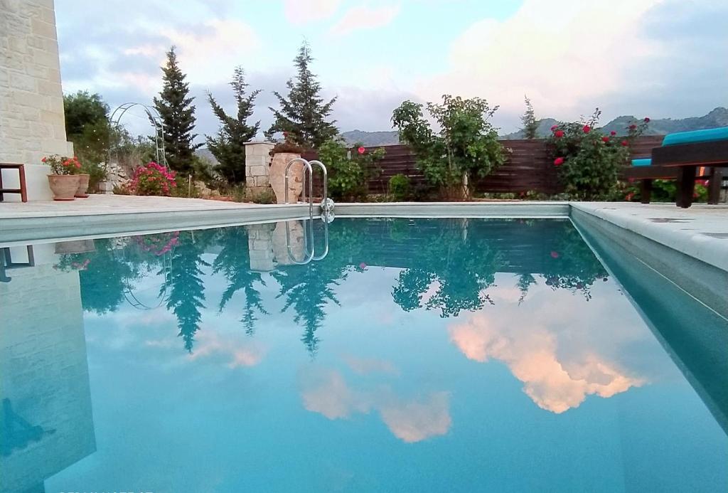 una piscina con reflejo del cielo en el agua en Little House on the Prairie - Chania, en Katokhórion