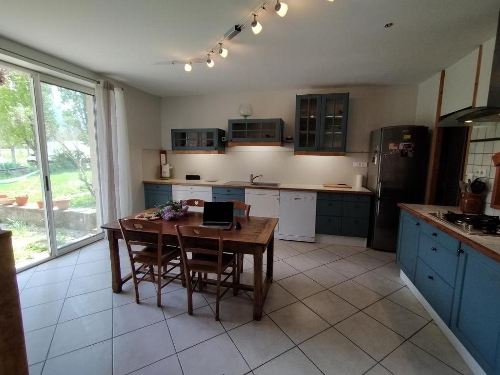 a kitchen with a wooden table and blue cabinets at domaine hermiton in Montlaur-en-Diois