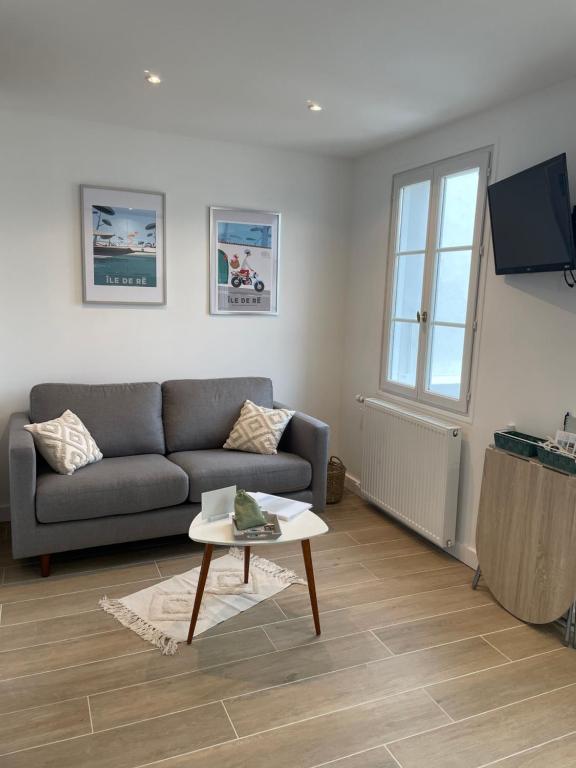 a living room with a couch and a table at Réalaplage studio de charme sur Rivedoux in Rivedoux-Plage