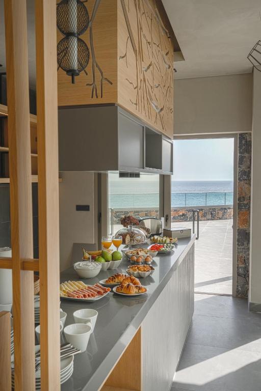 bufet z jedzeniem na nim z oceanem w tle w obiekcie panorama new generation w mieście Sfakia