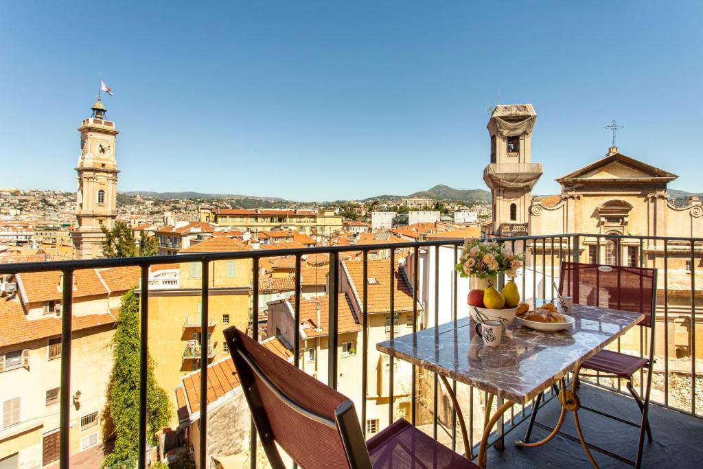 une table sur un balcon avec vue sur une ville dans l'établissement Providence - ELEGANT F3, VUE INCROYABLE, BALCON,ASCENSEUR, WIFI, à Nice