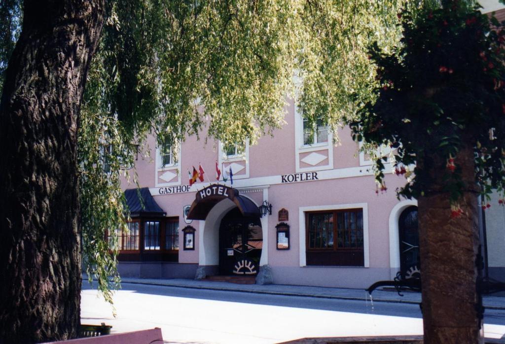 a pink building with an archway in front of it at Gasthof Brauerei Kofler in Rottenmann