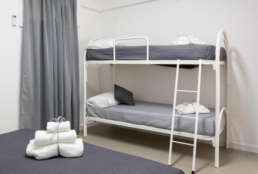 Zimmer mit 2 Etagenbetten und Handtüchern auf dem Boden in der Unterkunft Home & Bike Capelli di Venere in Casaletto Spartano